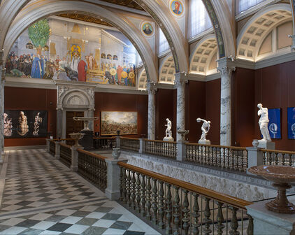 Storslagen trapphall med pelare, väggmålningar och skulpturer.