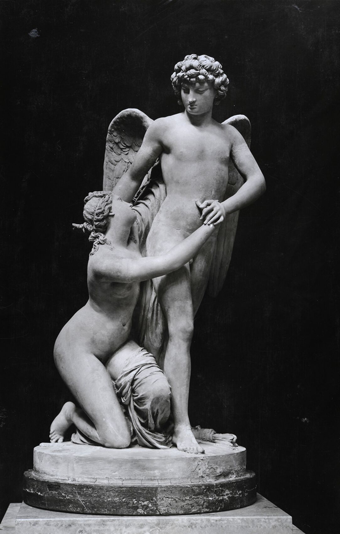 Sculpture of Amor standing and holding the hands of a kneeling Psyke.