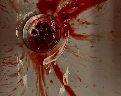 Blod som rinner ner i avloppet i ett handfat.